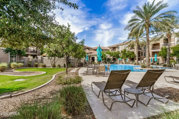 a view of a patio with a table and chairs under an umbrella