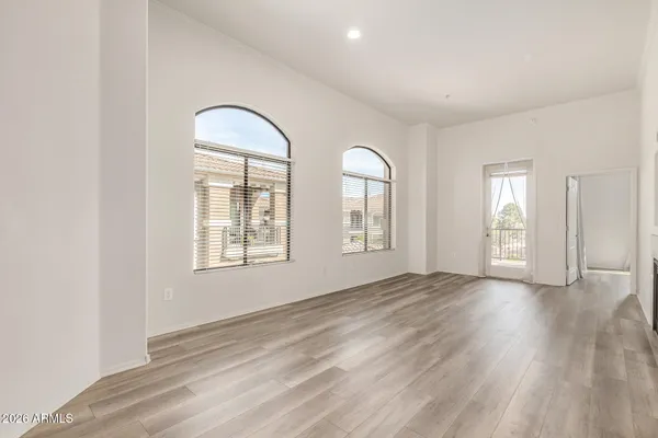 an empty room with wooden floor and windows