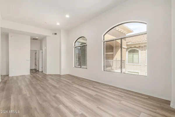 a view of empty room with window and wooden floor