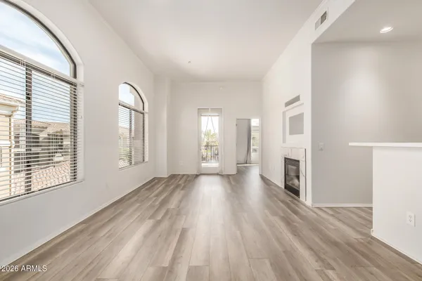 a view of empty room with fireplace and wooden floor