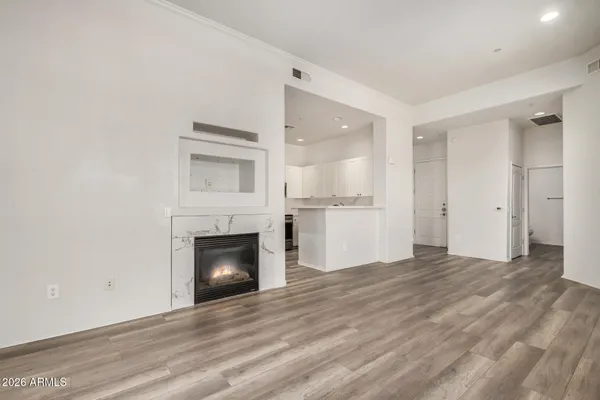 a view of empty room with wooden floor and fireplace