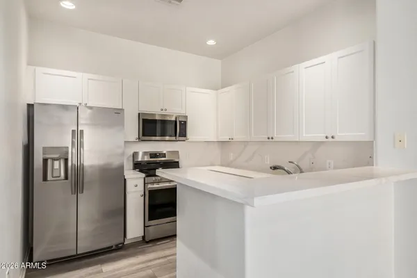 a kitchen with stainless steel appliances granite countertop a refrigerator and a stove top oven