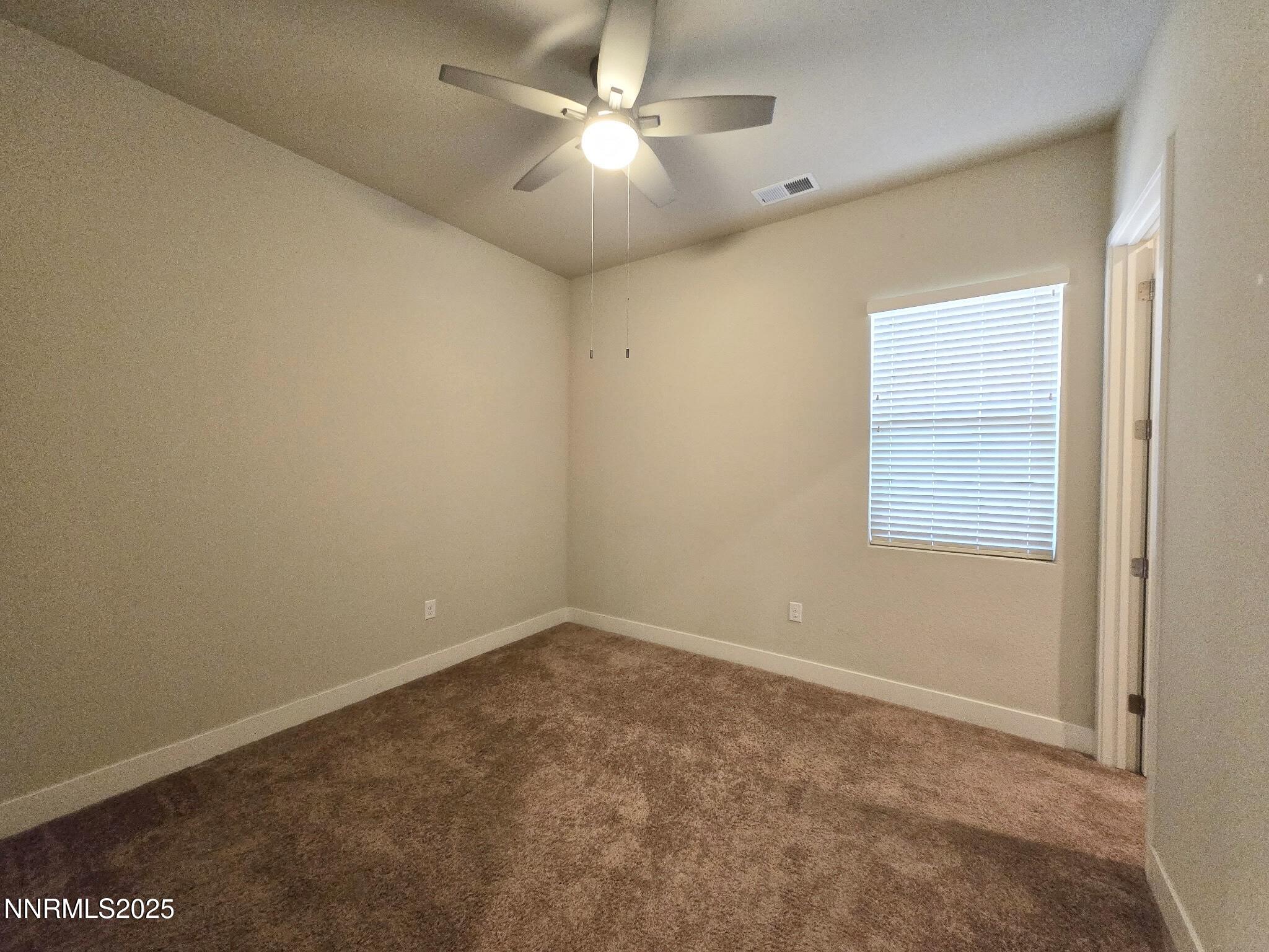 162 Jennys Lane Fernley, NV 89408 - Photo 19 of 39 an empty room with a window and a fan