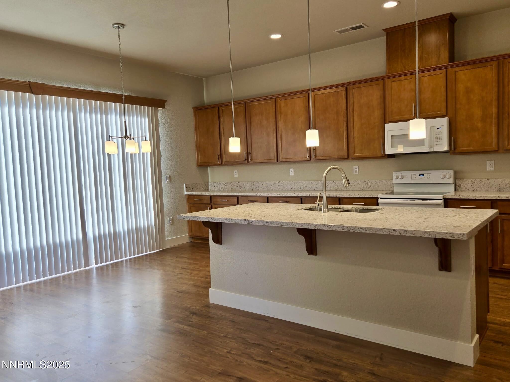 162 Jennys Lane Fernley, NV 89408 - Photo 6 of 39 a kitchen with kitchen island a sink wooden floor and a large window