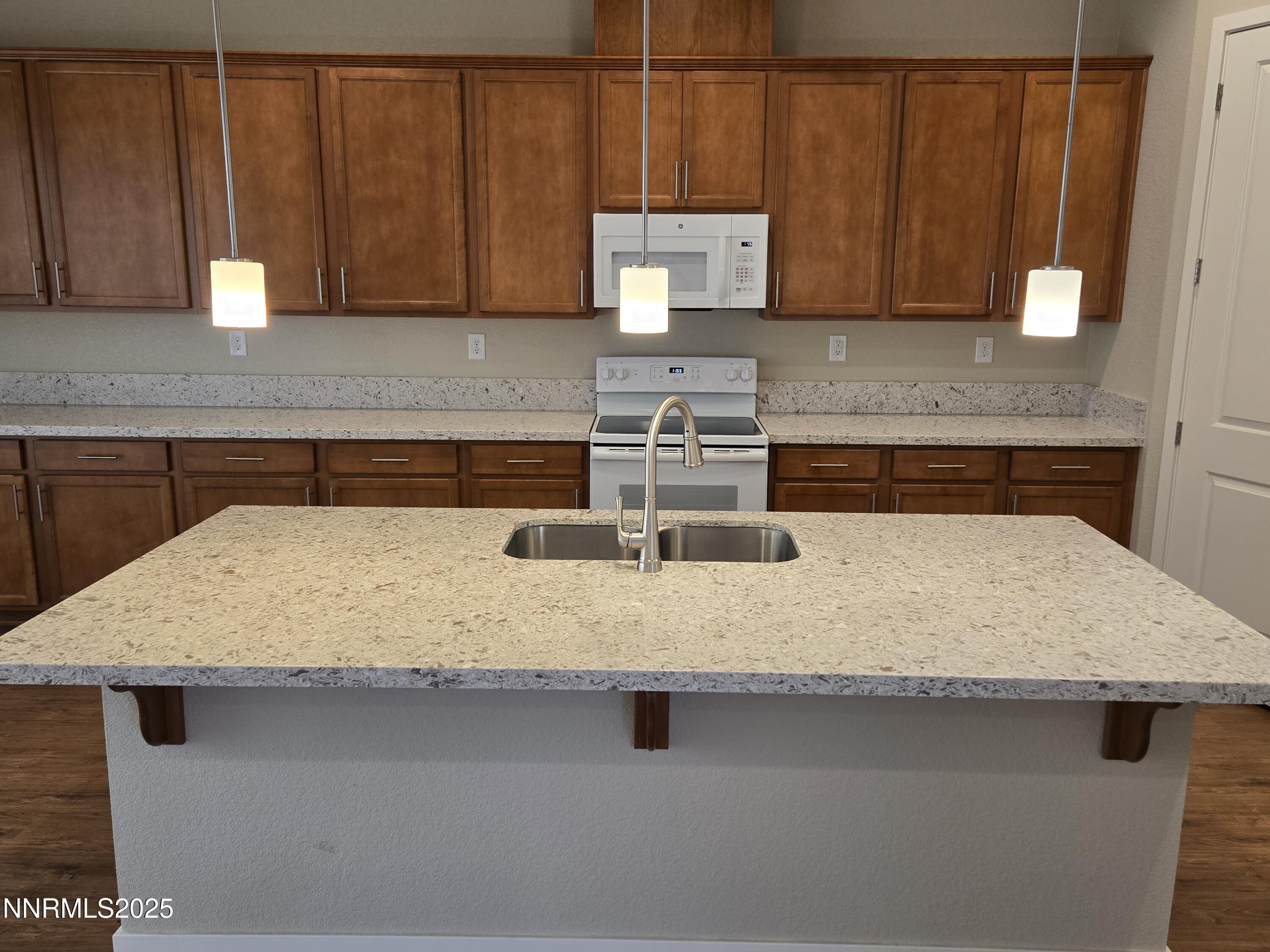 162 Jennys Lane Fernley, NV 89408 - Photo 9 of 39 a kitchen with kitchen island a sink a stove and wooden cabinets