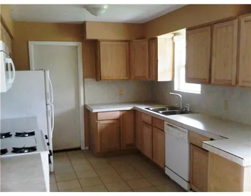a kitchen with a sink a refrigerator and window
