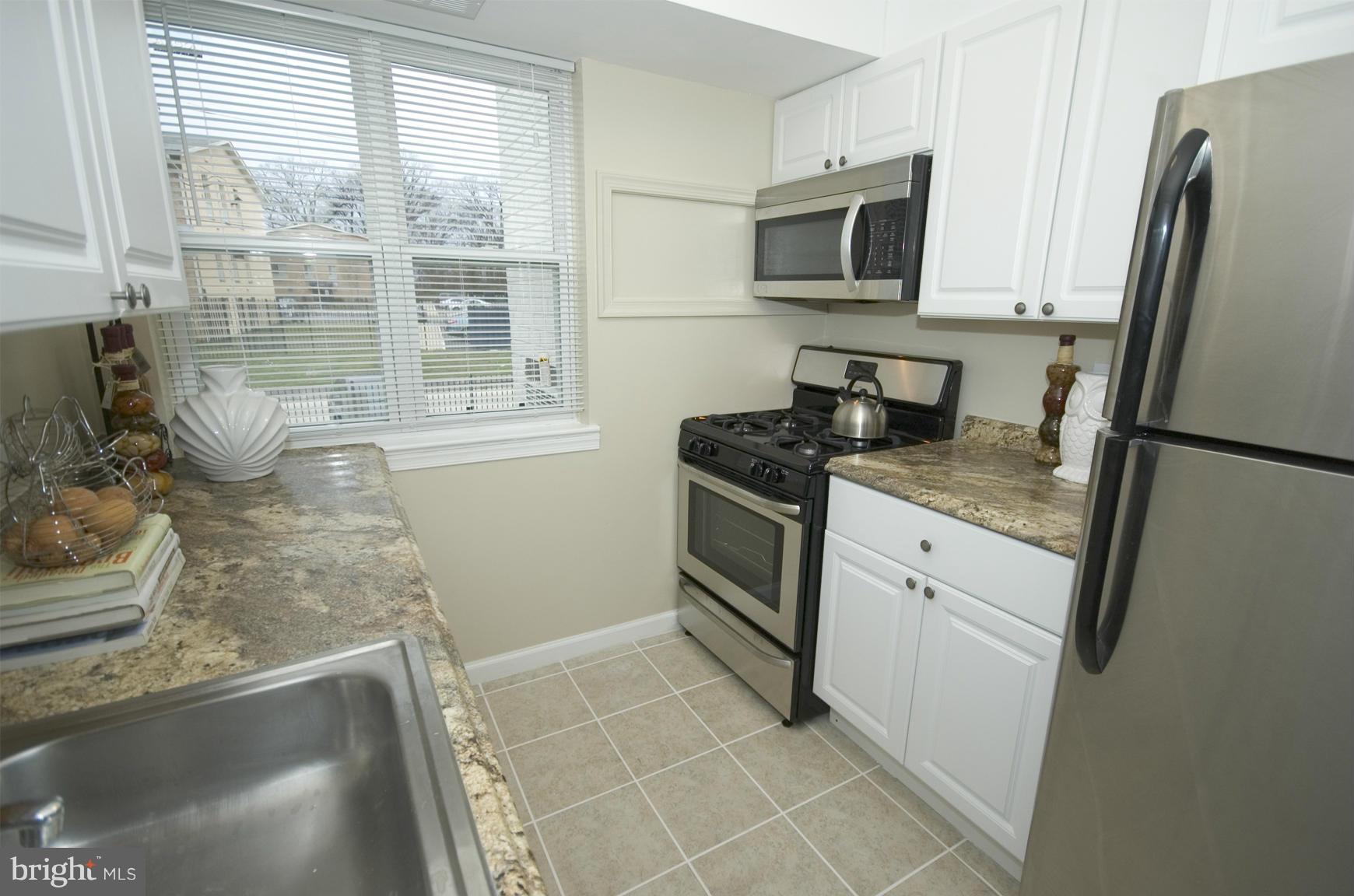 2351 16th Street Southeast, Unit 302 Washington, DC 20020 - Photo 14 of 27 a kitchen with a sink stove and refrigerator