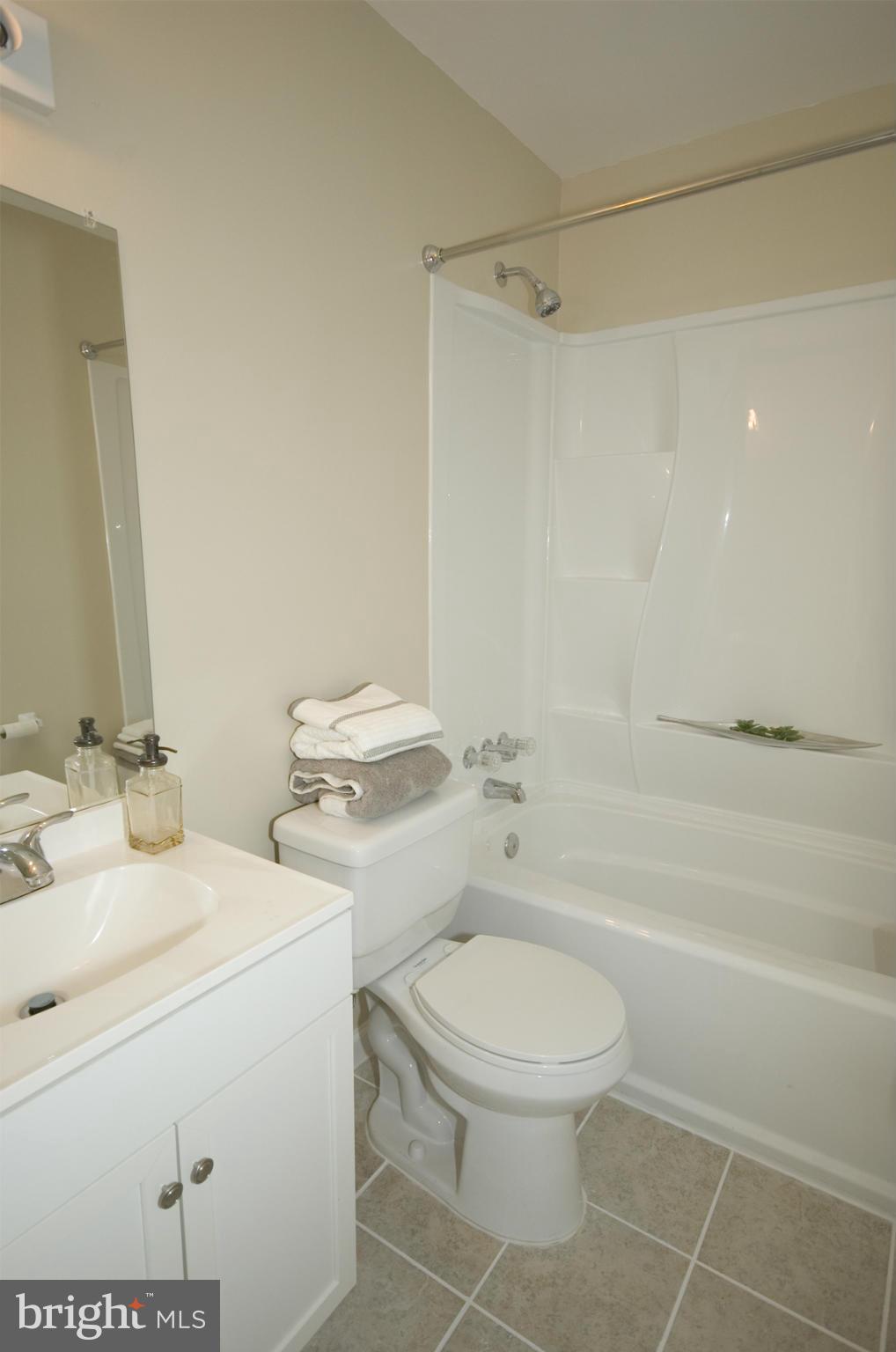 2351 16th Street Southeast, Unit 302 Washington, DC 20020 - Photo 19 of 27 a bathroom with a granite countertop toilet a sink and a bathtub