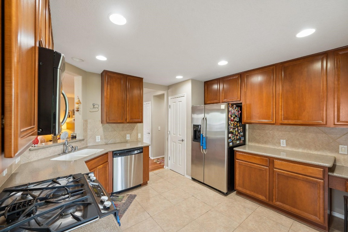 13600 Breton Ridge Street, Unit 25E Houston, TX 77070 - Photo 12 of 39 a kitchen with stainless steel appliances granite countertop a refrigerator and a stove top oven