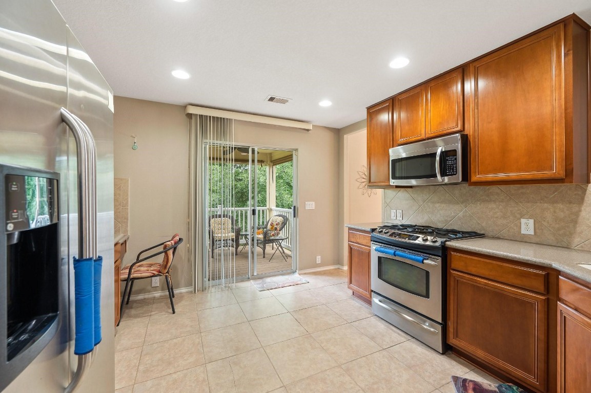 13600 Breton Ridge Street, Unit 25E Houston, TX 77070 - Photo 14 of 39 a kitchen with stainless steel appliances granite countertop wooden cabinets a stove top oven a sink and dishwasher