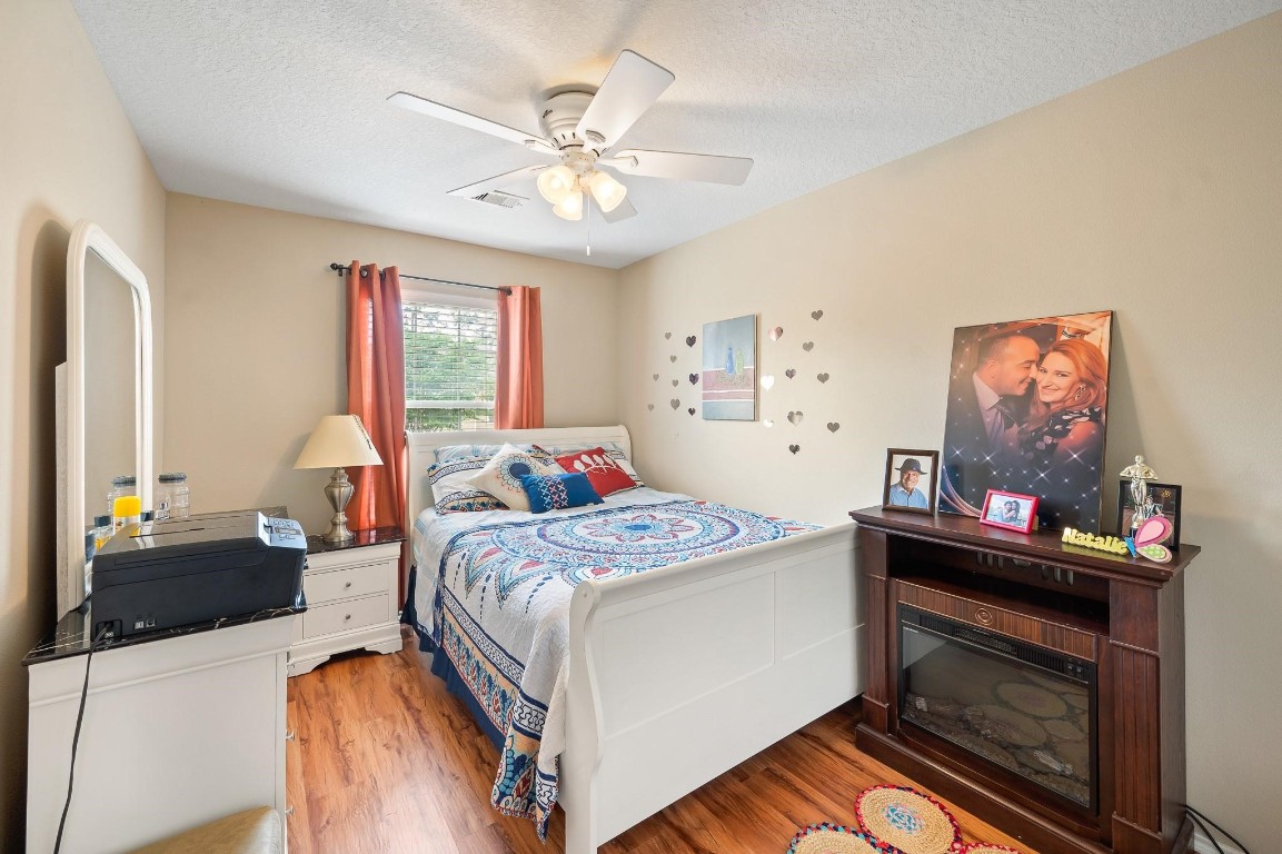 13600 Breton Ridge Street, Unit 25E Houston, TX 77070 - Photo 26 of 39 a bedroom with a bed and a chandelier