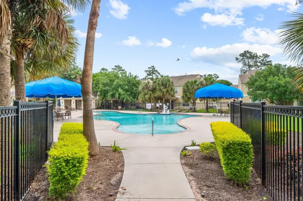 a view of a swimming pool with a table and chairs under an umbrella