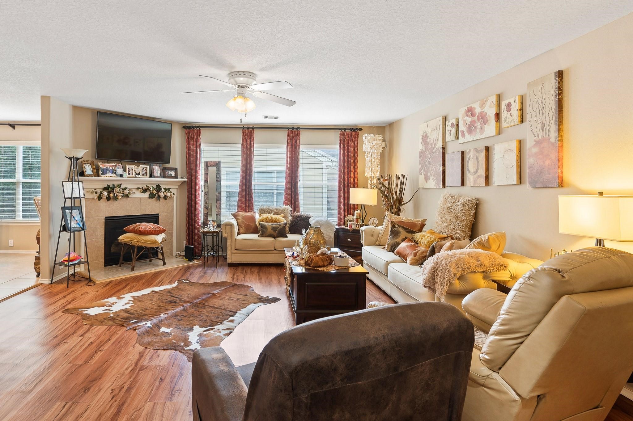 13600 Breton Ridge Street, Unit 25E Houston, TX 77070 - Photo 7 of 39 The living room features a gaslog fireplace, adding a touch of warmth and elegance. Large windows spanning the entire wall flood the room with natural light. The room provides a welcoming environment where everyone can feel comfortable and at ease!