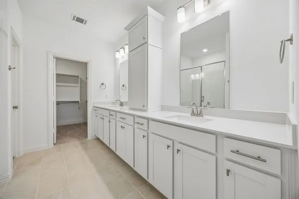 a spacious bathroom with double sink and a mirror