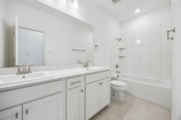 a bathroom with a double vanity sink toilet a shower and a bathtub