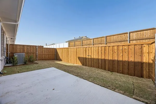 a view of backyard with wooden fence