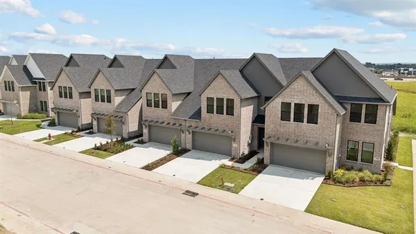 a view of a big house with wooden fence