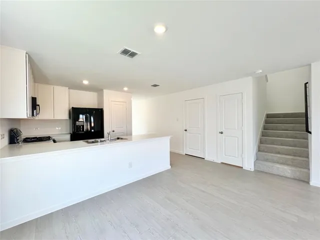 a large white kitchen with kitchen island a sink a stove and a refrigerator
