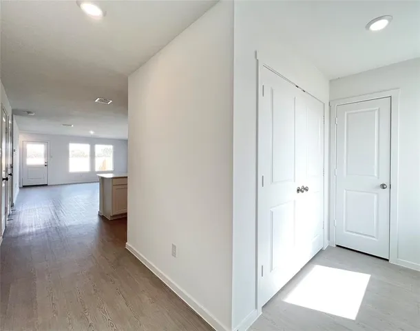 a view of a hallway with wooden floor