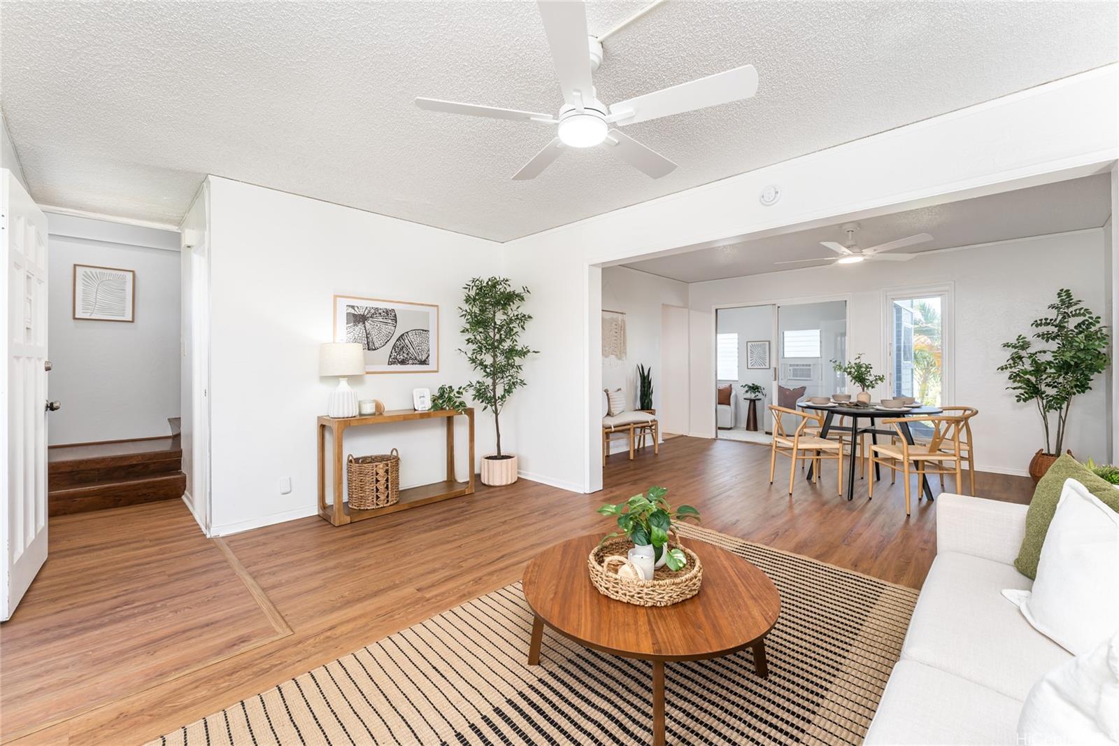 a living room with furniture and a wooden floor