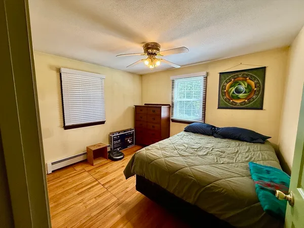 a bedroom with a bed and wooden floor