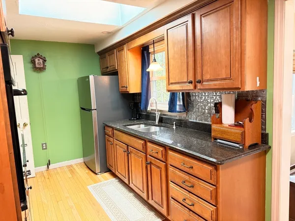 a kitchen with stainless steel appliances granite countertop next to a window