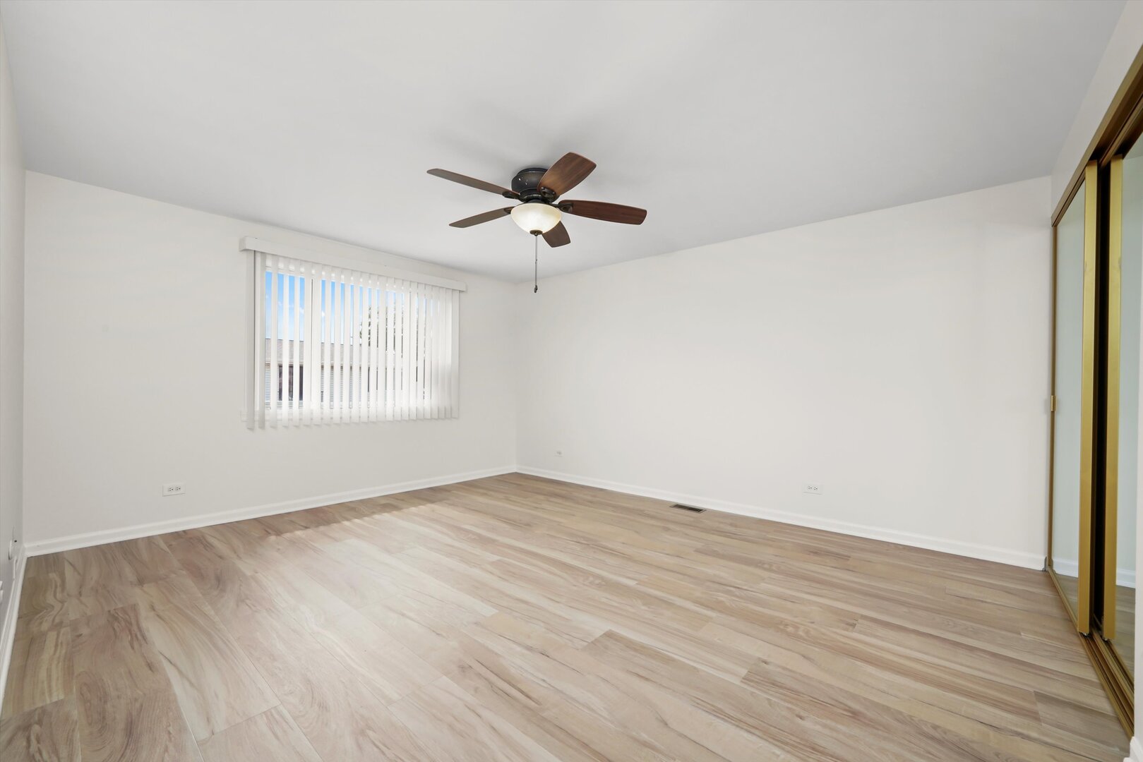 1100 Stoughton Court, Unit 1711 Schaumburg, IL 60193 - Photo 7 of 20 an empty room with wooden floor ceiling fan and windows