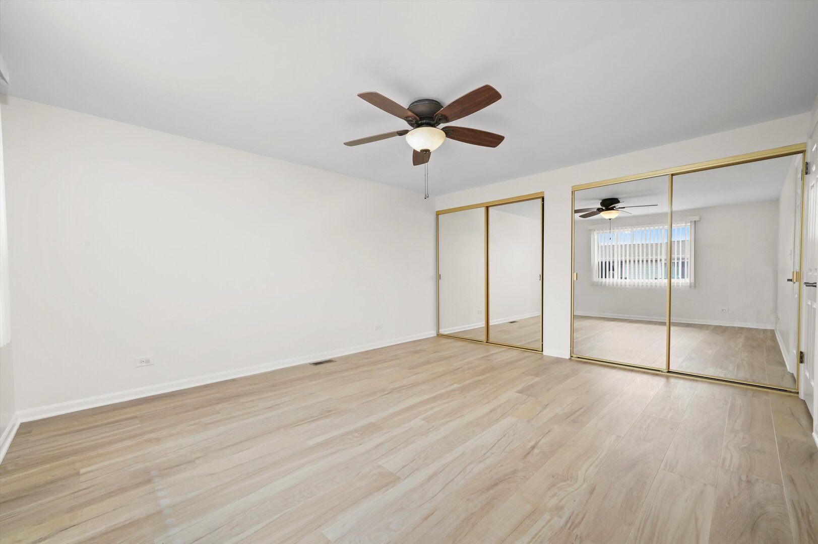 1100 Stoughton Court, Unit 1711 Schaumburg, IL 60193 - Photo 8 of 20 an empty room with wooden floor ceiling fan and windows
