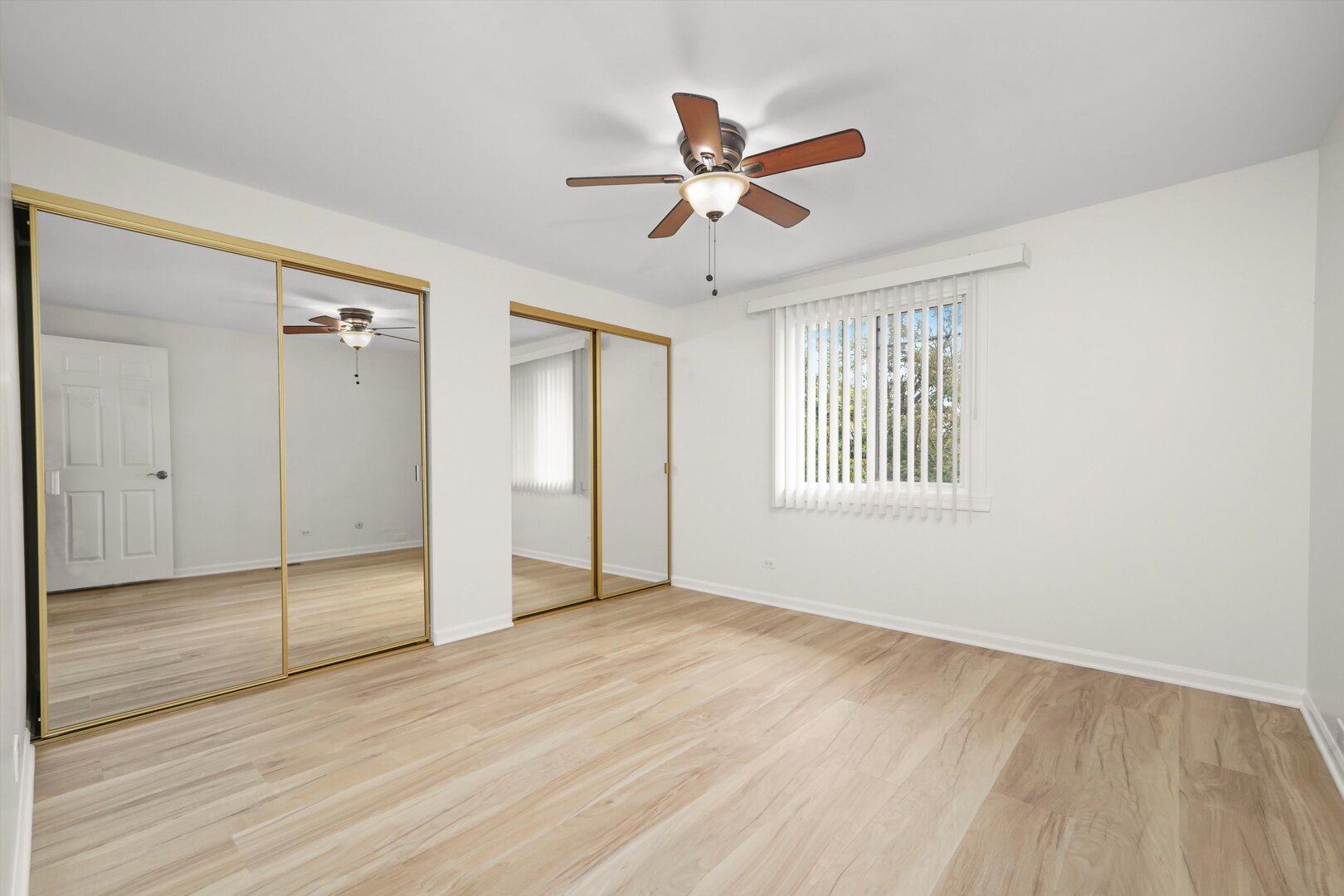 1100 Stoughton Court, Unit 1711 Schaumburg, IL 60193 - Photo 9 of 20 a view of empty room with wooden floor and fan
