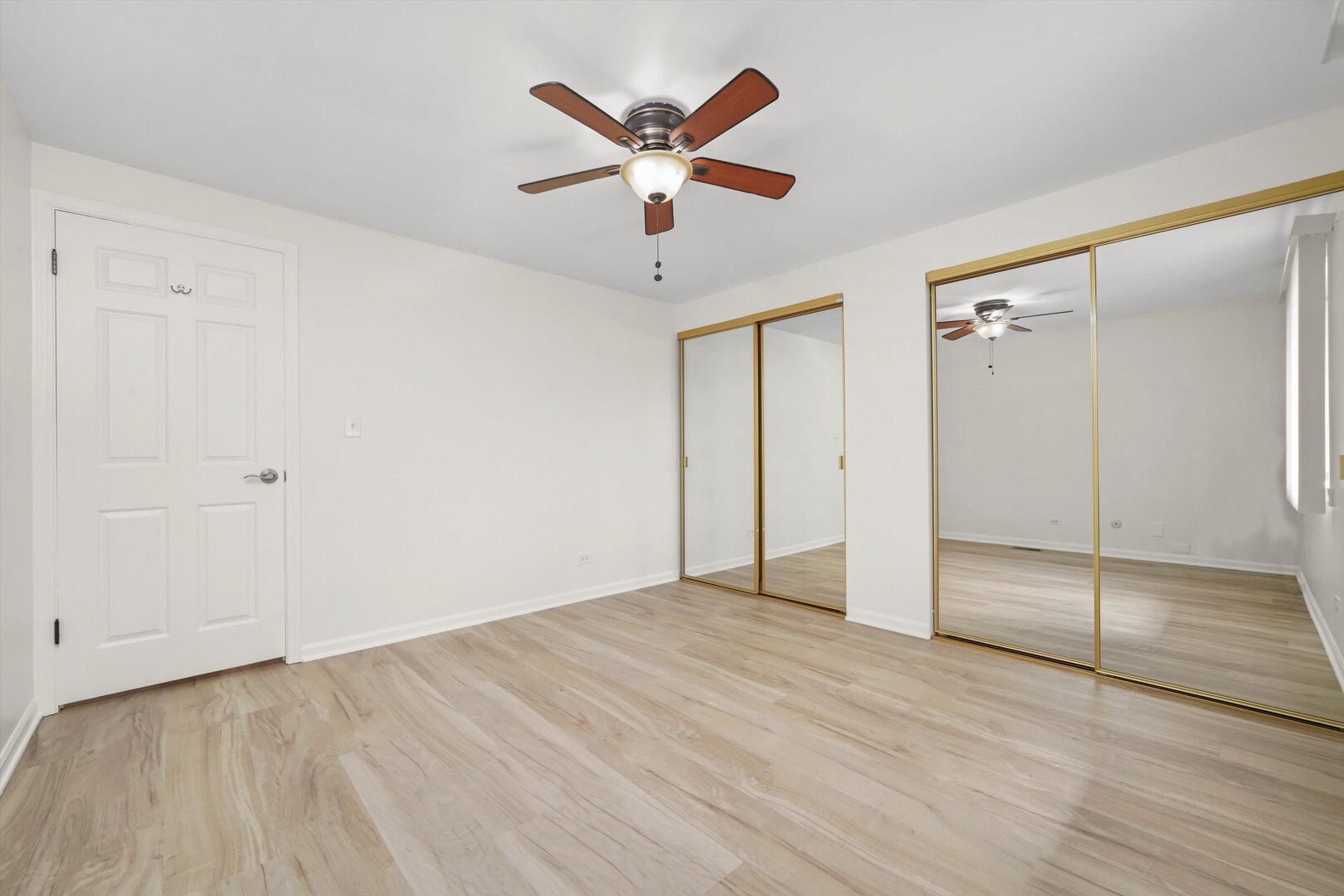 1100 Stoughton Court, Unit 1711 Schaumburg, IL 60193 - Photo 10 of 20 wooden floor in an empty room with a ceiling fan