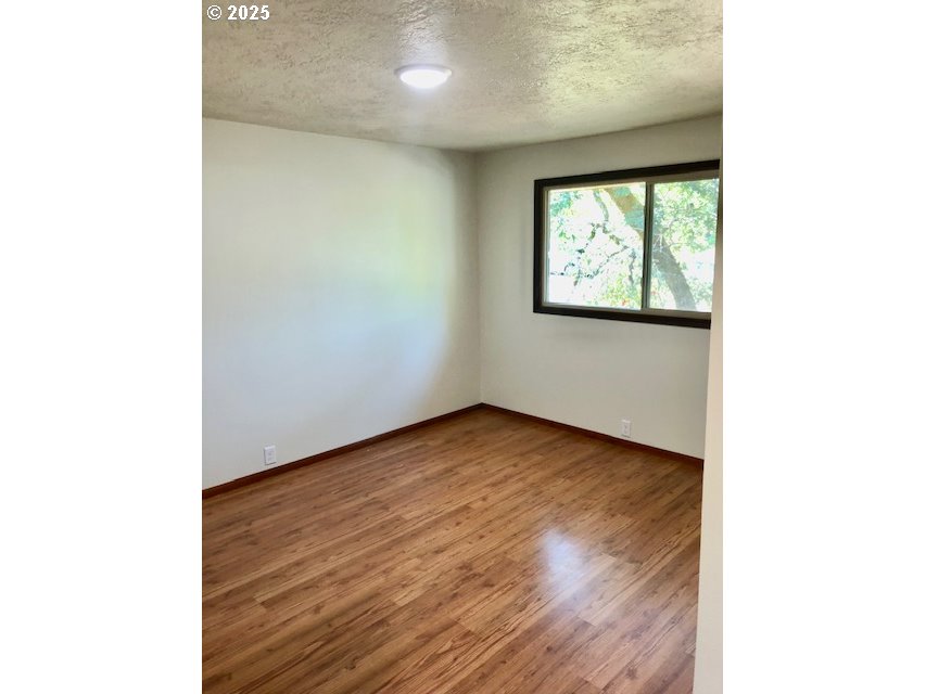 2765 Almaden Street Eugene, OR 97405 - Photo 12 of 24 a view of an empty room with wooden floor and a window