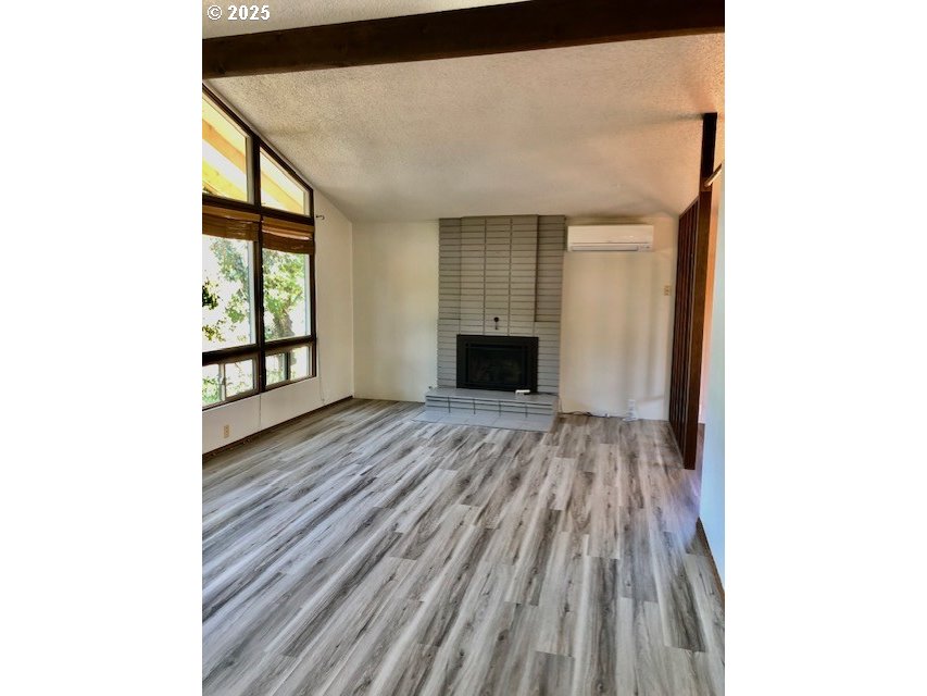 2765 Almaden Street Eugene, OR 97405 - Photo 3 of 24 a view of an empty room with wooden floor and a window