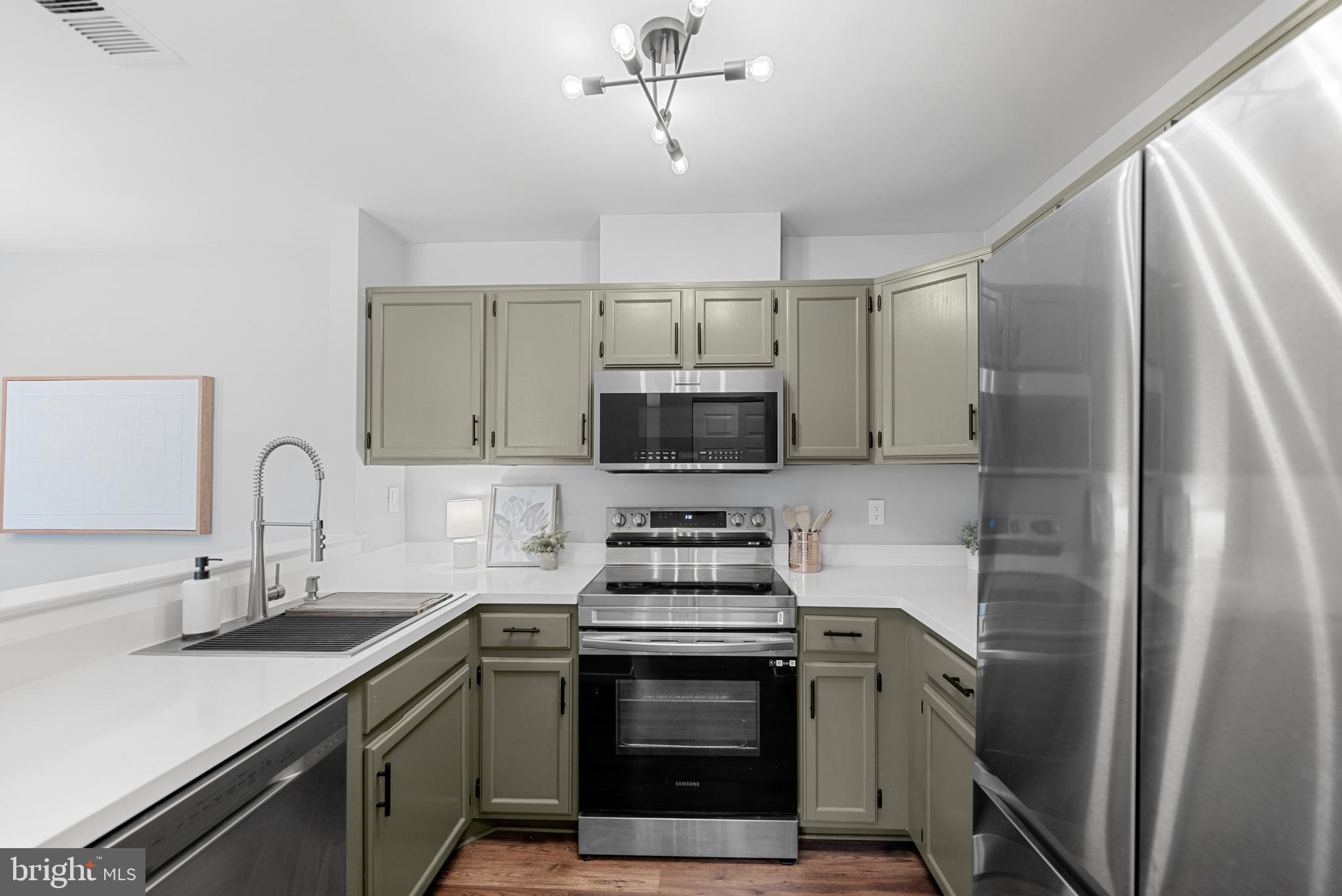 7826 Harrowgate Circle, Unit D Springfield, VA 22152 - Photo 7 of 21 a kitchen with stainless steel appliances a stove a sink and a refrigerator