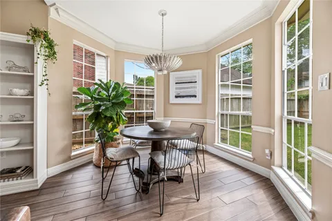 a dining room with furniture window and wooden floor