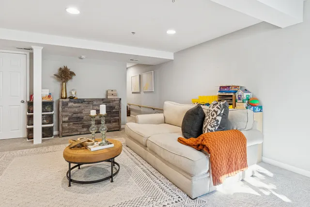 a living room with furniture a rug and white walls