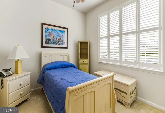a bedroom with a bed and a dresser next to a window