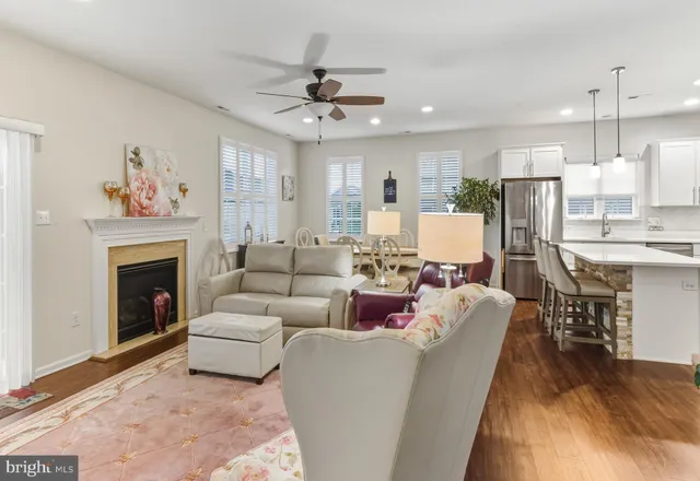 a living room with furniture a fireplace and a open kitchen view