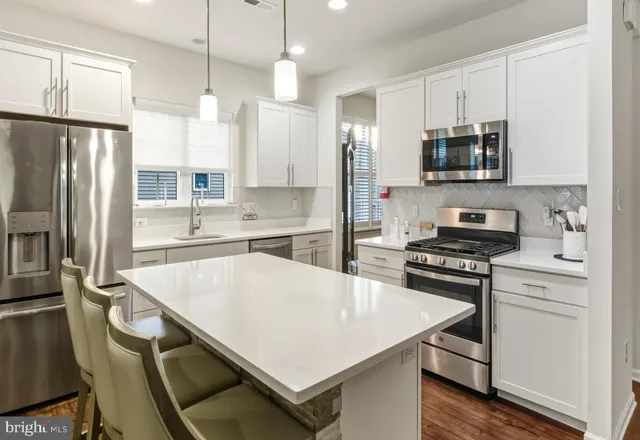 a kitchen with stainless steel appliances a stove refrigerator sink and microwave