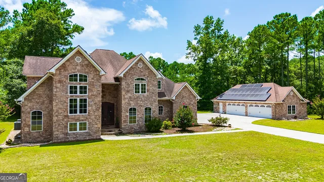 a front view of a house with yard and green space