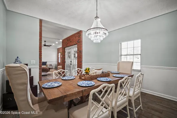 a view of a dining room with furniture and chandelier