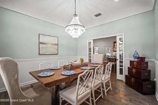 a kitchen with stainless steel appliances granite countertop a kitchen island hardwood floor sink stove dining table and chairs