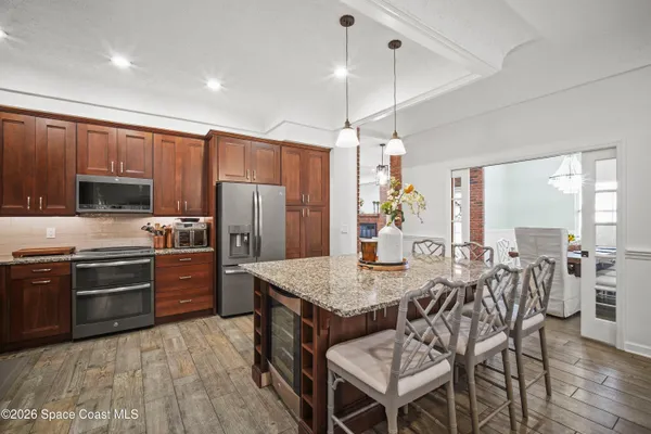 a kitchen with granite countertop a refrigerator stove and microwave