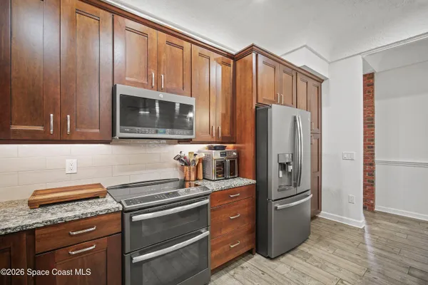 a large kitchen with kitchen island a stove a sink a dining table and chairs