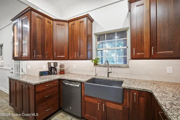 a kitchen with granite countertop a refrigerator and a sink
