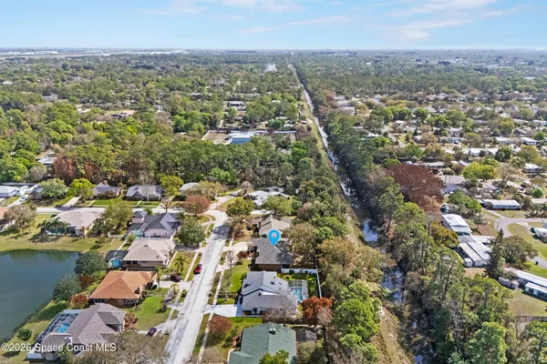 an aerial view of residential houses with outdoor space and trees