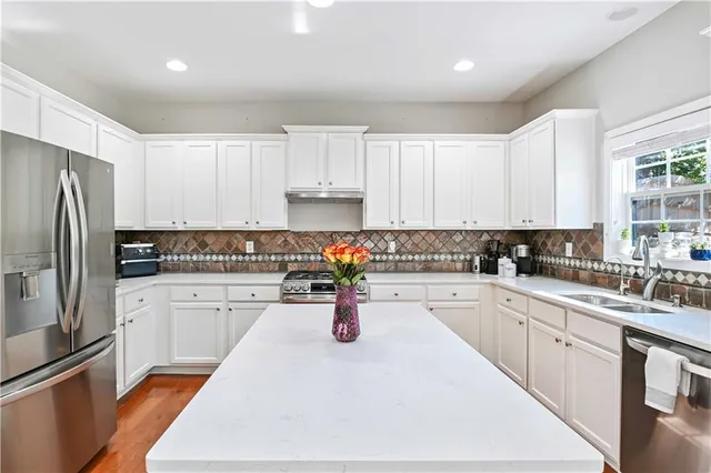 a kitchen with white cabinets stainless steel appliances and sink