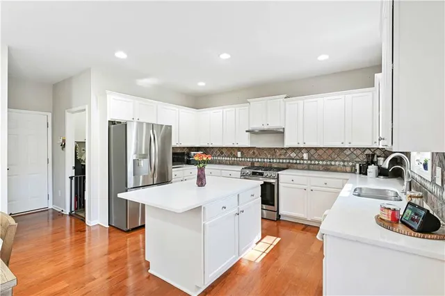 a kitchen with a refrigerator sink and cabinets