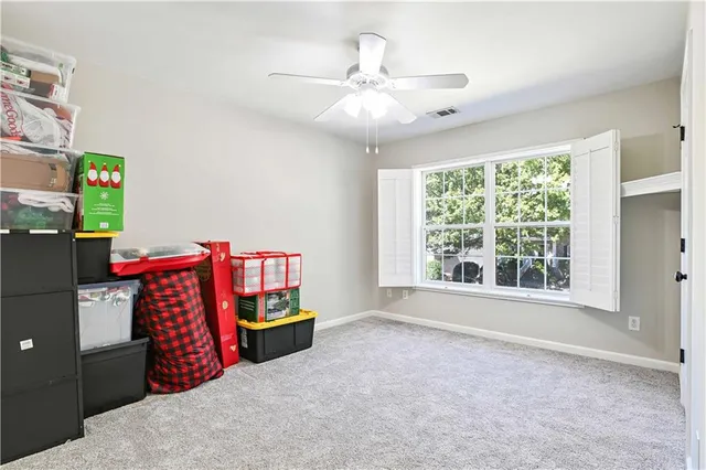 a view of an empty room with window and cabinet area