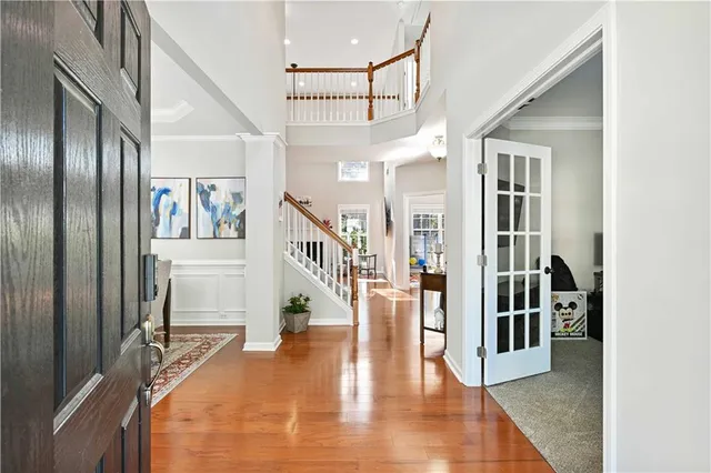 a view of a hallway with entryway and wooden floor