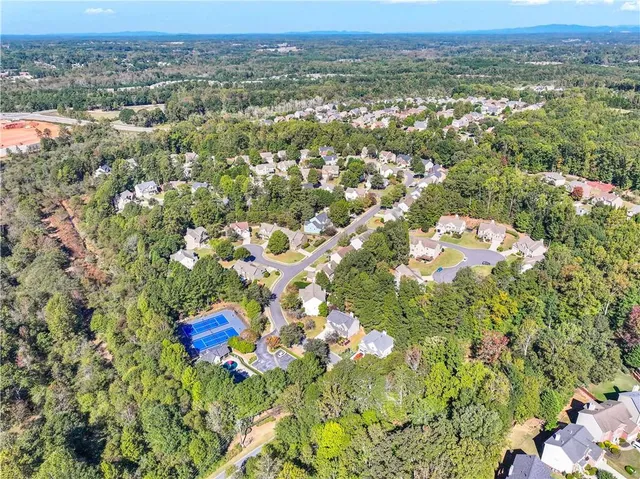 an aerial view of residential houses with outdoor space and trees